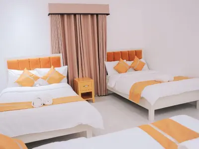 a bedroom with two beds with orange and white at Villa Excellance Beach and Wave Pool Resort in Postema