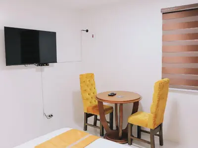 a room with a table and two chairs and a tv at Villa Excellance Beach and Wave Pool Resort in Postema