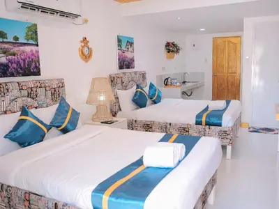 two beds in a hotel room with blue and white at Villa Excellance Beach and Wave Pool Resort in Postema