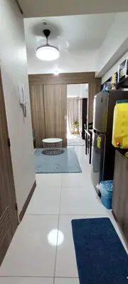 a kitchen with a white floor and a black refrigerator at Amesha Staycation in Manila