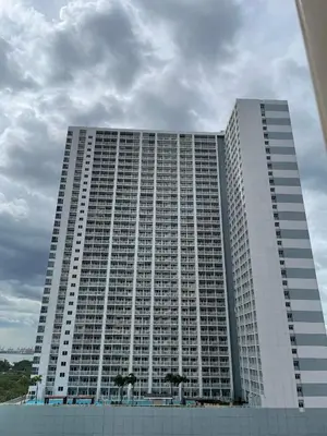 a large white building with trees in front of it at Amesha Staycation in Manila