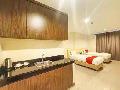 a bathroom with a bed and a kitchen with a sink at Kaizen Suites in Manila