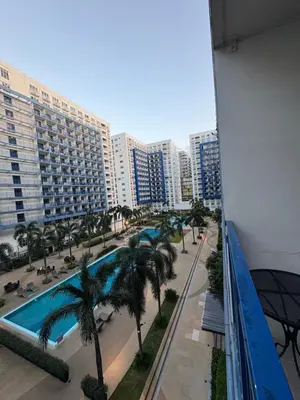 a view from the balcony of a hotel with a pool and palm trees at Sea Residences JEREMIAH2911-MALACHI310 in Manila