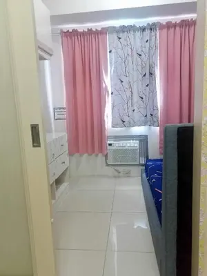 a small bathroom with pink curtains and a window at Sea Residences JEREMIAH2911-MALACHI310 in Manila