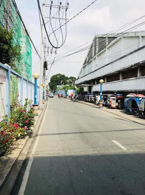 an empty street with cars parked on the side of a building at THE MANSION - 24-HOUR Near AirPort Hostel 4 Backpackers in Manila