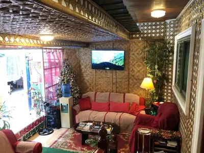 a living room with a couch and a tv on a wall at THE MANSION - BACKPACKERS Near AIRPORT in Manila