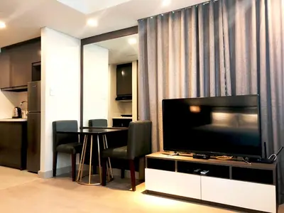 a living room with a television and a table with chairs at The Residences at BCCT in Manila
