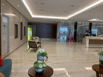 a lobby with tables and potted plants in a building at SMDC Coast Residences Roxas Boulevard corner Pasay Condo Unit in Manila