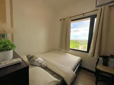 a small bedroom with a bed and a window at Althea's Cozy Home - Condo in Las Pinas in Manila