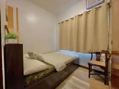 a small room with a bed and a chair at Althea's Cozy Home - Condo in Las Pinas in Manila