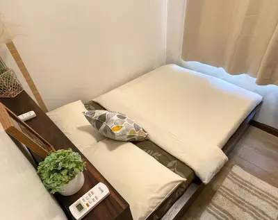 a small room with two beds and a remote control at Althea's Cozy Home - Condo in Las Pinas in Manila