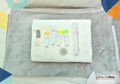 a group of toothbrushes and other items on a bed at The City Flats Sacred Heart in Manila