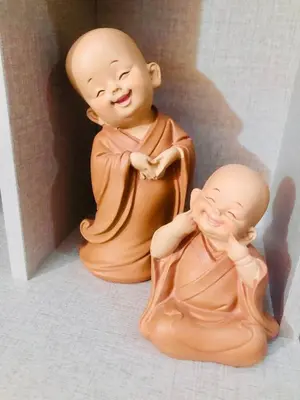 two monk statues sitting next to each other at Air residence 1BR with balcony FREE NETFLIX in Manila