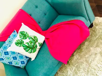a green couch with two pillows on it at Air residence 1BR with balcony FREE NETFLIX in Manila