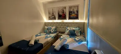 a small room with two beds in a room at Spacious Studios in Manila