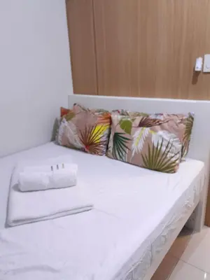 a white bed with pillows and a napkin on it at vin's place 1br amenities view at Shell Residence in Manila