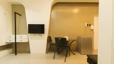 a room with a table and chairs and a television at SOUTHPICKRESORT & HOTEL INC. in Aplaya