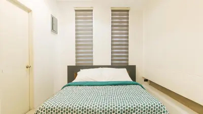 a bedroom with a bed in a white room at SOUTHPICKRESORT & HOTEL INC. in Aplaya