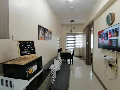 a living room with a stove and a dining room at Pasay Coast Residences JCMJ in Manila