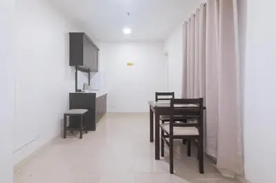 a dining room with a table and chairs and a tv at Propiedad Residences Makati in Manila
