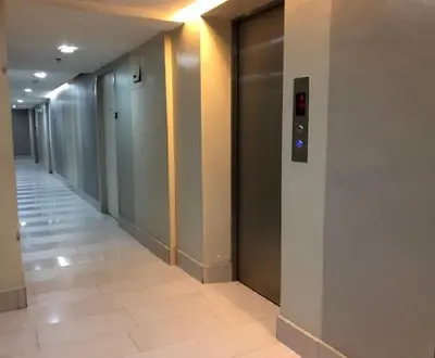a hallway of an office building with a elevator at 2 BR loft-type condo Fort Victoria in Manila