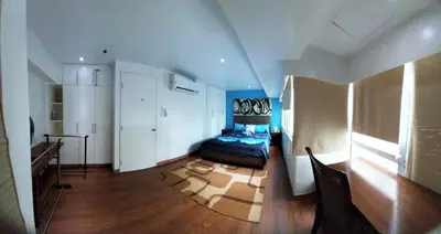 a bedroom with a bed in the middle of a room at 2 BR loft-type condo Fort Victoria in Manila