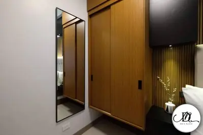 a bedroom with a mirror and a wooden cabinet at DM's Place at S Residences MOA in Manila