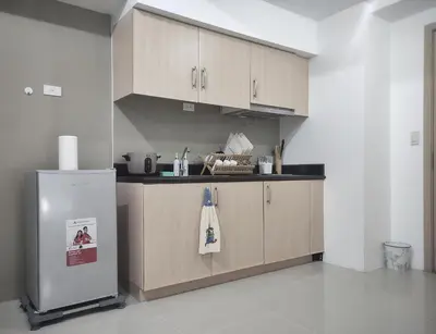 a kitchen with wooden cabinets and a refrigerator at Amazing Condo at SMDC Light Residences Boni Avenue Mandaluyong in Manila