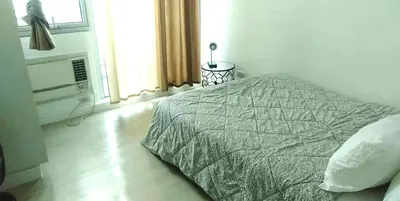 a white bedroom with a bed and a window at Azure Urban Resort Residence a2 in Manila