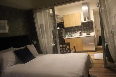 a bedroom with a large bed and a kitchen at Azure Urban Resort Residence a2 in Manila
