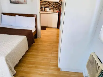 a bedroom with two beds and a wooden floor at Azure Urban Resort Residence A1 in Manila