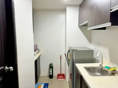 a small kitchen with a sink and a refrigerator at 2BR w Balcony in Araneta, Cubao w Pool and Gym - Porto Vita in Manila