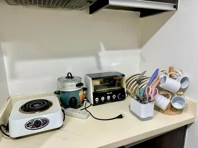 a kitchen counter with a toaster and a toaster and a microwave at 2BR w Balcony in Araneta, Cubao w Pool and Gym - Porto Vita in Manila