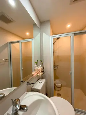 a bathroom with a shower and a toilet and a sink at Downtown Nook - Azure Urban Resort Residences in Manila