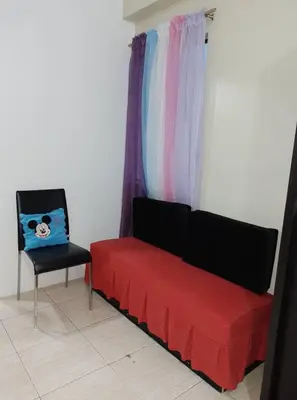 a living room with a red couch and a chair at Budget Friendly Condo for Rent in Valley Mansions in Cainta