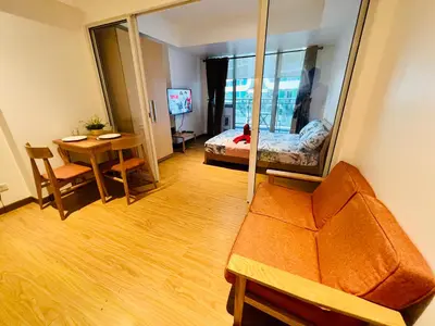 a living room with a couch and a mirror at Azure Pool View w/ Netflix & Wifi Boracay Tower in Manila