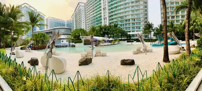 a pool with chairs and rocks in a resort at Azure Pool View w/ Netflix & Wifi Boracay Tower in Manila
