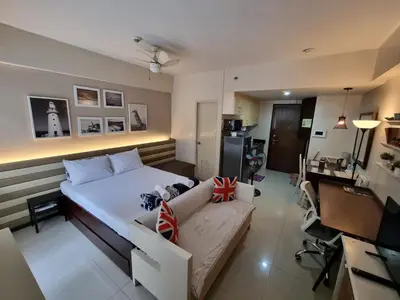 a bedroom with a bed and a couch and a desk at Palm Tree Villas Condominium by Beth in Manila