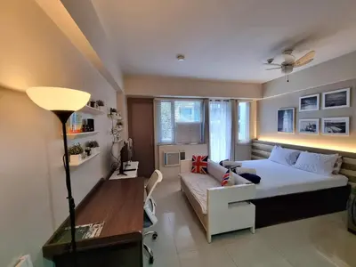 a bedroom with a bed and a desk and a couch at Palm Tree Villas Condominium by Beth in Manila