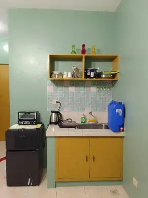 a small kitchen with a sink and a stove at Affordable Staycation in Valley Mansions near Sitio Elena Events Place in Cainta