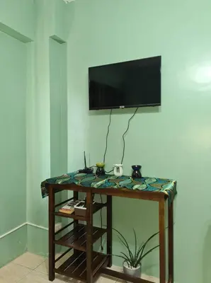a room with a table with a television on a wall at Affordable Staycation in Valley Mansions near Sitio Elena Events Place in Cainta