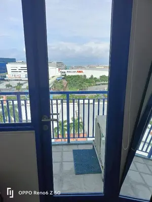 an open door to a balcony with a view of the ocean at Jamescrabsea residences in Manila