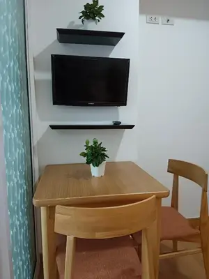 a wooden table with a tv on a wall at Happirest at Azure Urban Resort Residences, Paranaque City in Manila