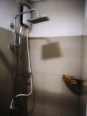 a shower in a bathroom with a shower head at Serenity Cove MOA in Manila