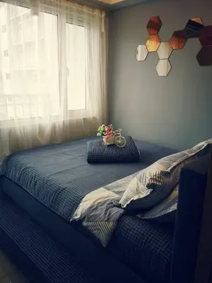 a bedroom with a bed with a window and a flower pot on it at Serenity Cove MOA in Manila