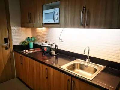 a kitchen counter with a sink and a microwave at Serenity Cove MOA in Manila
