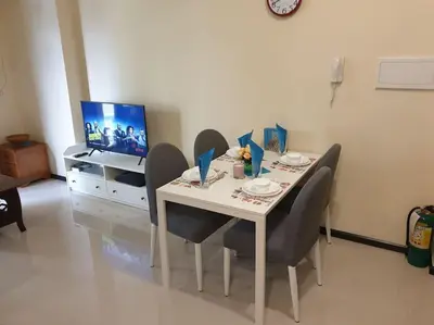 a dining room table with chairs and a television at The Radiance by Dominga in Manila