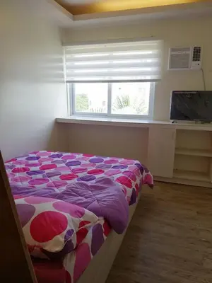 a bed in a bedroom with a window in a room at Stanford Suites 2 Lilian in Silang
