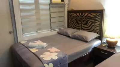 a bedroom with a bed with flowers on it at 2 separate fully furnished condo units 1BR on the 23rd flr and 3BR penthouse on the 41st flr, with different bookings and daily rates in Ermita, Manila near SLEC,US Embassy, Mall and Parks in Manila