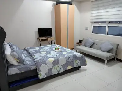 a bedroom with a bed and a couch at 101 condo furnished walking distance NIAA 3 in Manila